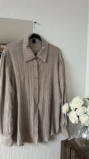 Beige randig skjorta  - Tunt och lite texturerat material. Köpt på plick och säljer vidare då det var fel storlek för mig.
