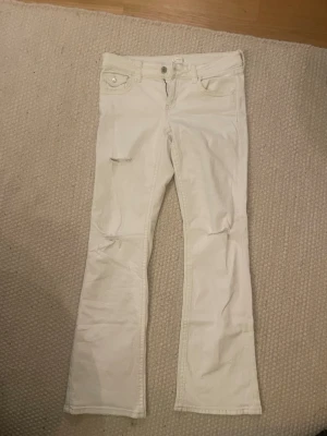 Vita bootcut jeans - Vita bootcut jeans med lite hål på benen. 