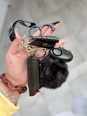 Nyckelknippa från Benjii shop - Säljer en svart marbel knippa med svart pompom, bältskärare och fönsterkross, lamp med lampa och dörröppnare med pektouch för smartphone och kapsylöppnare och försvarsspray.