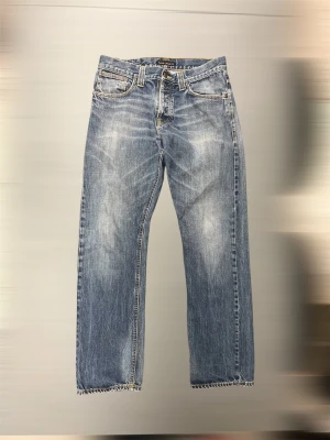 Vintage Archive Nudie Jeans Average Joe  - (Straight), köp inte med bring ⚠️  Schyssta vintage Nudie jeans i modellen ”Average Joe” som är en straight leg utan taper. Dateras bak till 2014🔥 Storlek W34 L34 men passar mer som W32 L32. Har en minimal defekt, men inget som stör (sista bilden). Jag sätter storleken som W32. Se mått nedan, och läs noga för jag gör ej returer!☃️  Midja: 42 cm Ytterbenslängd: 106-107 cm Benöppning: 20,5 cm  Vänligen notera att mått kan skilja 1-2 cm. Jag mäter alltid så noggrant som möjligt. 