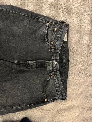 Levi's 501 svarta jeans, storlek 31/32 - Säljer ett par klassiska Levi's 501 jeans i svart tvättad denim. Modellen har raka ben, hög midja och knäppning med knappar framtill.