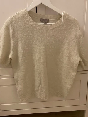 Vit stickad kortärmad topp - Använd mycket, kortärmad stickad från hm, köpt 2023. Söt och inte jätte nopprig.
