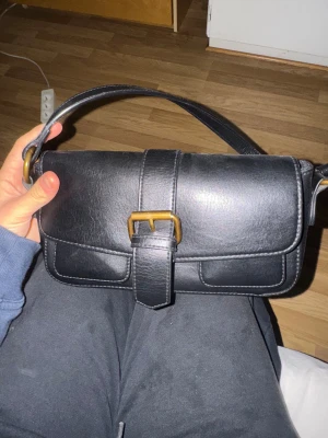 Svart axelväska med gulddetaljer - Väska från brandy Melville 