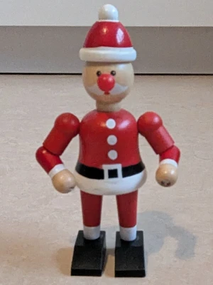 Röd tomte i trä - Säljer en klassisk tomte i trä, röd med vit kant och vit boll på toppen. En söt dekorativ tomtefigur. Perfekt för att ge julkänsla till rummet eller som rolig inredningsdetalj. Med hjälp av din hand kan du röra huvud, ben och armar och skorna på tomten i olika riktningar. Tomten är rörlig med din hjälp 