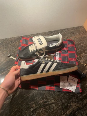 Adidas x Wales bonner - Adidas x Wales Bonner helt nya skor i storlek 44. Väldigt exklusivt samarbete mellan Adidas och designern Grace Wales Bonner, kända för sin premiumkvalitet och unika design med inspiration från klassiskt Adidas-arv och lyxiga materialval. Nypris 6499 kr, digitalt bevis finns på sista bilden. Mitt pris 3999 kr då det inte går att returnera efter 14 dagar, slå gärna en pling vid intresse. Fanns bara storlek 44 kvar, skulle väntat tills 44,5 istället men det går tyvärr inte att ändra. Helt nya och 