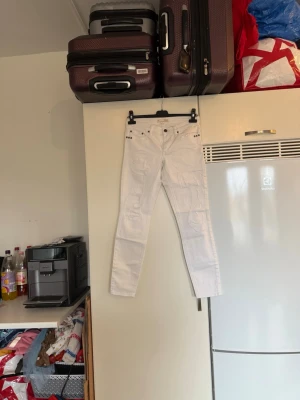Vita ripped jeans från Odd Molly - Snygga vita jeans från Odd Molly med slitna detaljer och nitar vid fickorna. Modellen är slim och har klassisk femficksdesign. Jeansen är tillverkade i bomull och har en fräsch, modern look som passar perfekt till sneakers eller boots. Storlek 1 som enligt deras storleksguide motsvarar en storlek S. mer använd men fortfarande fint skick. 