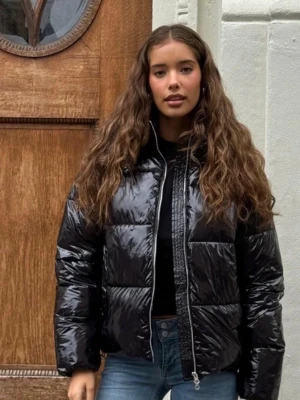 Shiny Puffer Jacket - Säljer en svart glansig pufferjacka med dragkedja och avtagbar huva. Inga tecken på användning, endast ett år gammal. Jackan är från Nelly (”Everyday Shiny Puffer Jacket”). Nypris 799kr 👉🏼 Säljer för 349kr❣️😱