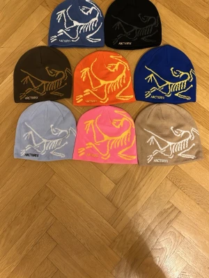 Mössor från Arc'teryx, skriv vilken färg du vill ha - Snygg ljusblå mössa från Arc'teryx med stort vitt fossiltryck på framsidan. Stickad i mjukt material som sitter skönt på huvudet och har en clean look med loggan broderad framtill. Perfekt för dig som gillar outdoor och streetstyle.