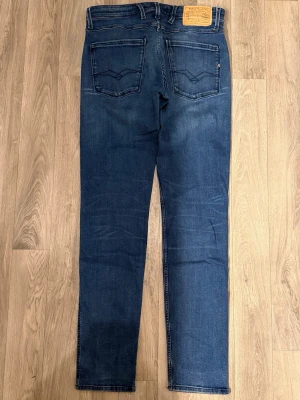 Replay Anbass Jeans Blå W31 L34 - Blåa Replay Anbass jeans i fint skick (Finns obehandlade fläckar & lite slitet i skrevet). Mått - Midja: 40cm, Benlängd: 107cm. Modellen är 185cm & 63kg. Hör av dig vid funderingar!🤩