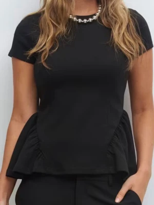 Svart blus med volangdetaljer - Snygg svart blus med korta ärmar och volangdetaljer på sidorna. Toppens design är stilren och passar perfekt till både jeans och kostymbyxor. Materialet känns mjukt och har en lätt struktur. Perfekt för dig som gillar minimalistisk stil med en twist. Passar storlek M också💕