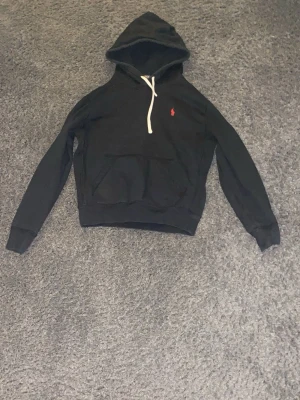 Ralph lauren Hoodie svart S - En snygg svart Ralph lauren hoodie med rött emblem och vita snören. Snygg året runt. Bra skick. Storlek S. Prutat och klart 350 kr.