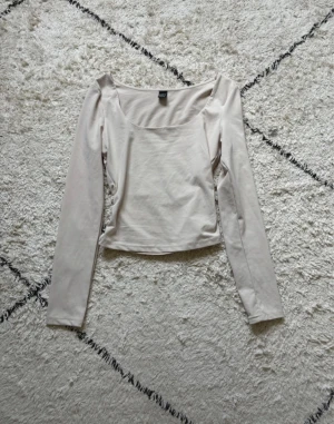 Beige långärmad topp från SHEIN - Säljer en stilren beige topp från SHEIN i storlek XS Petite. Toppen har lång ärm, fyrkantig ringning och är croppad i modellen. Materialet är mjukt och stretchigt, perfekt för att matcha med jeans eller kjol. Enkel och snygg design som passar till många olika looks.