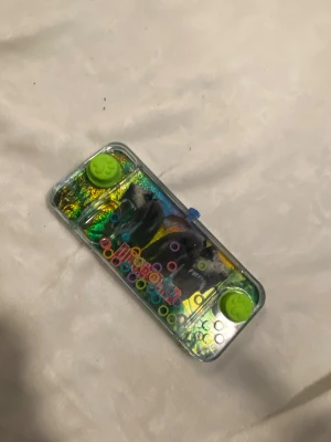 Ingen väst synlig på bilderna - Det finns ingen väst på någon av bilderna. Bilderna visar leksaker, bland annat en vattenleksak, gosedjur och en leksaksmotorcykel.