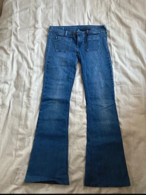 Lågmidjade jeans - Snygga blå jeans med bootcut och låg midja. Har sytt om dem själv så finns några skavanker här och där