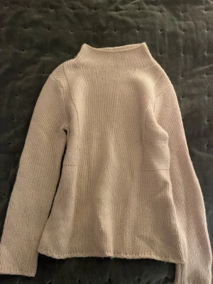 Beige polotröja från Hemisphere - Säljer en stilren beige polotröja från Hemisphere. Tröjan är stickad med grov struktur och har lång ärm samt hög krage. Perfekt för dig som gillar enkel och clean design med mjukt material. Passar dig som vill ha en klassisk look.