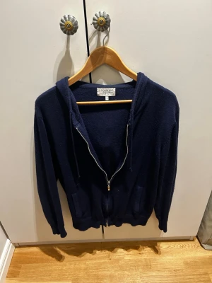 Mörkblå Kashmir hoodie från Livano - Säljer en mörkblå Kashmirblend hoodie från Livano köpt för 2 år sedan och jag säljer eftersom att den inte passar längre. Priset är inte hugget i sten så tveka inte på att höra av dig vid frågor eller funderingar! 