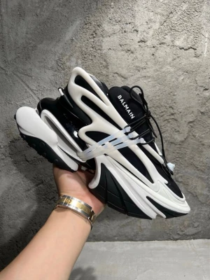 Balmain unicorn - Säljer ett par Balmain sneakers i svart och vitt med chunky sula och futuristisk design. Skorna har snörning och tydliga vita detaljer som kontrasterar mot den svarta basen. Märket syns på plösen och materialet är en mix av syntet och skinn. Uk8