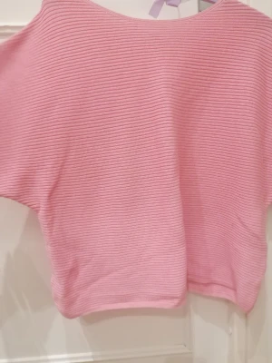 Rosa ribbad poncho - tröja från Kappahl - Säljer en ljusrosa ribbad poncho - tröja från Kappahl i storlek S. Tröjan har en loose passform och är tillverkad i ett stickat material med horisontella ränder. Perfekt för dig som gillar mjuka och bekväma plagg med enkel design. Den är endast använd ett fåtal gånger & sitter lite "oversized" på mig som vanligtvis bär storlek XS! ☺️