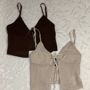 2 toppar från Divided, XXS - Två toppar från Divided i storlek XXS. En är brun och den andra beige, båda med smala axelband och knytning framtill. Topparna har en luftig, virkad struktur och croppad passform. Supersnygga på men passar inte mig längre. Säljer båda tillsammans! Skriv för flera bilder 🥰