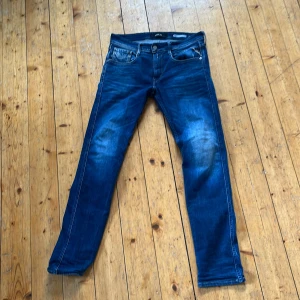 Blå Replay jeans, midwaist, storlek 31/32 - Snygga blå jeans från Replay med klassisk femficksdesign och coola slitningar på låren. Jeansen har raka ben och normal passform, tillverkade i mjukt denimtyg. Perfekta för dig som gillar en stilren och tidlös look.