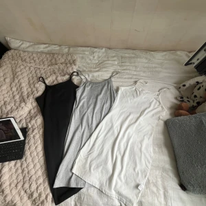 Tre baslinnen i svart, grått och vitt - Säljer tre enkla och stilrena linnen med smala axelband i svart, ljusgrått och vitt. Perfekta att styla lager på lager eller bära som de är. Alla har en rak, något längre passform och är tillverkade i mjukt material som känns skönt mot huden. Från Temu