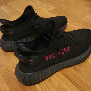 Adidas Yeezy Boost 350 Black/Red - Säljer ett par Adidas Yeezy Boost 350 i svart med röda detaljer och texten SPLY-350 på sidan, Skönaste skorna som finns.