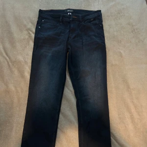 Svarta jeansbyxor från Diesel - Snygga svarta jeansbyxor från Diesel med klassisk femficksdesign och raka ben. Jeansen har en mörk tvätt och diskreta detaljer, perfekt för en stilren look. Materialet är mjukt och följsamt jeans, vilket gör dem bekväma att bära hela dagen.
