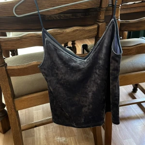 Blå sammetslinne från H&M Divided XS - Mörkblå sammetslinne från H&M Divided i storlek XS. Linnet har smala axelband och en v-ringad fram- och baksida. Materialet är mjukt och glansigt, vilket ger en lyxig känsla. Perfekt för dig som gillar en stilren men ändå trendig look.