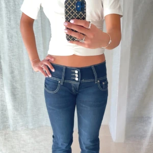 Mörkblå lågmidjade bootcut jeans - Så fina lowaist bootcut jeans med många knappar framtill! 🌸  Märke: Tkolp Färg: Mörkblå 💙 Material: Stretch  Midjemått: 37 cm Innerbenslängd: 82 cm  Vid frågor är det bara att höra av sig! 😊 Bundle = rabatt  💕 