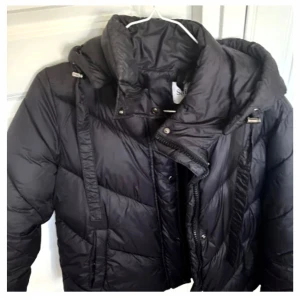 Svart jacka  - Säljer en svart jacka från Saint Tropez i storlek XS. Jackan har huva med snörning, dragkedja och tryckknappar framtill. Den är vadderad.. Har bara använts några gånger, bara och skriva om ni har frågor💕