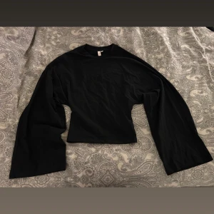 Svart långärmad topp från Nelly - Svart långärmad topp från Nelly i modellen 'Wide Sleeve LS Top. Helt ny med prislapp kvar 