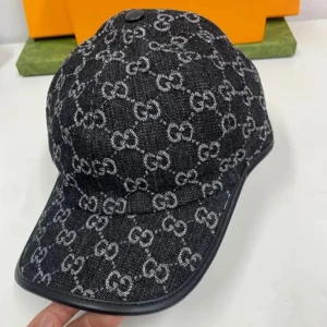 Svart keps från Gucci i jeans - Snygg svart keps från Gucci i jeansmaterial med klassiskt GG-mönster i vitt över hela kepsen. Böjd skärm och svarta detaljer längs kanten ger en exklusiv känsla. Perfekt accessoar för att lyfta din outfit.