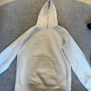 Vit hoodie från Zara med huva - Vit hoodie från Zara i storlek S. Klassisk modell med stor känguruficka framtill och huva. Tillverkad i mjuk bomull, perfekt för chill dagar. Enkel och stilren design utan tryck eller mönster.