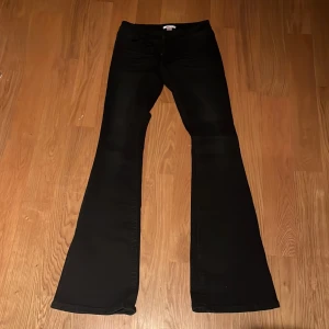Svarta bootcut jeans från Gina Tricot - NYA, ALDRIG ANVÄNDA. Säljer ett par svarta bootcut jeans från Gina Tricot i storlek S 14+. Byxorna har snygga detaljer med små silvriga nitar på bakfickorna och klassisk femficksmodell. Perfekta för dig som gillar en lite utsvängd look och vill sticka ut lite extra.