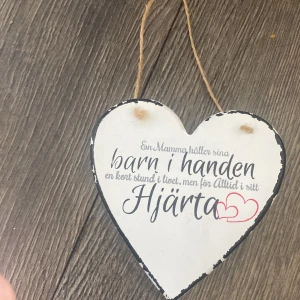 En Mamma håller sina barn i handen - Hjärformad skylt med texten: 'En Mamma håller sina barn i handen en kort stund i livet, men för Alltid i sitt Hjärta'. Perfekt som present eller dekoration för att visa kärlek och omtanke. Passar dig som gillar inspirerande citat och personlig inredning.
