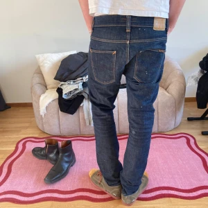 Nudie jeans - Snygga mörkblå jeans från Nudie Jeans med klassisk femficksdesign och kontrastsömmar. Perfekta för en stilren look. De har en normal passform och är tillverkade i högkvalitativt denim. Modell grim tim. Hittar inte storlek men uppskattar ca30/30 