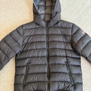 Svart dunjacka från Colmar med huva - Säljer en svart dunjacka från Colmar med huva. Jackan är stilren med horisontella sömmar och har en clean look med Colmar-logga på ärmen. Perfekt nu för lite kallare dagar. Storlek M men passar även bra för S. Har använt jackan 5-10 gånger. Modellen på bilden är ungefär 172 och väger drygt 65kg. Det är bara att höra av sig vid funderingar, pris kan diskuteras vid snabb affär🙂. Nypris ca 3000kr 