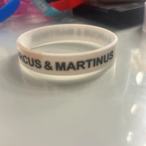Marcus & Martinus vitt silikonarmband - Vitt armband i silikon med svart text 'MARCUS & MARTINUS' runt om. Perfekt accessoar för fans som vill visa sitt stöd för sina idoler. Enkel och stilren design som passar till allt. !!pris kan diskuteras!!