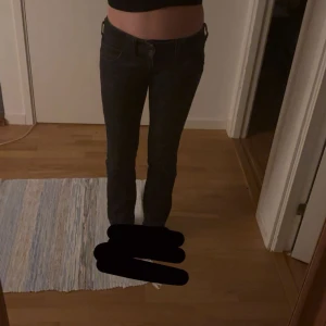 Svarta Armani Jeans bootcut - Snygga svarta jeans från Armani Jeans med klassisk bootcut och coola bakfickor med broderad logga. Jeansen har låg midja och är tillverkade i mjukt denimtyg som sitter riktigt bra. Perfekta för dig som gillar en stilren och tidlös look. storlek 28