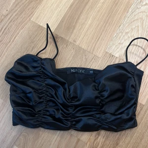 Topp  - Svart glasig topp från Nelly stl xs, aldrig använd 