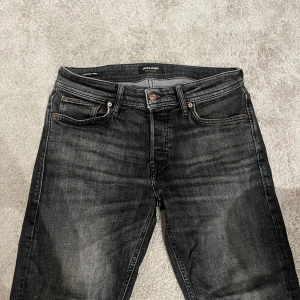 Svarta tapered jeans från Jack & Jones - Snygga svarta jeans från Jack & Jones med tapered passform. Jeansen har klassisk femficksdesign, knappgylf och diskreta slitningar för en snygg look. Dem är tapered/mike i storlek 29/32. Det är bara höra av er i dm vid ev frågor eller funderingar! / Michael