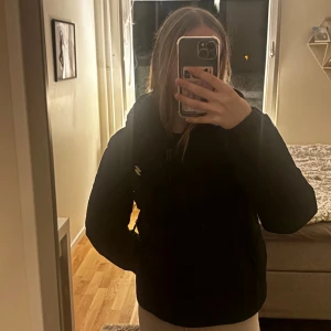 Svart pufferjacka från Superdry, st xs - Säljer en svart pufferjacka från Superdry med klassisk passform och diskret logga på bröstet. Jackan har dragkedja framtill, hög krage och är vadderad för extra värme. Perfekt för kyliga dagar och enkel att matcha med allt.