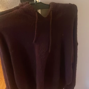 Mörklila hoodie med huva och snörning -  mörkröd hoodie med huva och snörning i halsen. 