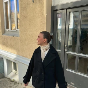 Svart skepparkavaj med stora slag - Säljer den svarta kända design by si kappan med knappar framtill. Den har inga märken eller defekter. Säljer den då den inte kommer till användning Storleken är Xs/s🫶🫶