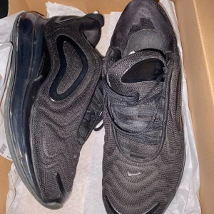 Nike Air Max 720 helsvarta sneakers - Nike Air Max 720 sneakers i helsvart med futuristisk design och synlig maxdämpning i sulan. Ovandel i mesh och syntet med coola vågformade detaljer och diskret Swoosh-logga. Skorna har snörning och en chunky plattformssula som ger extra höjd och streetkänsla.