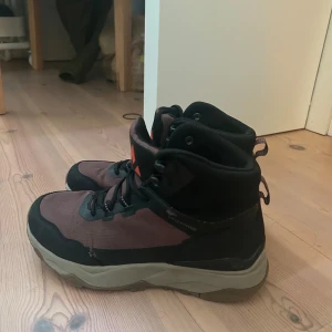 Whistler bruna kängor med snörning - Säljer ett par bruna och svarta kängor från Whistler med robust sula och snörning. Skorna har hög modell och är perfekta för utomhusaktiviteter. Ovandelen är i slitstark textil och syntet, med logga framtill och grovt mönstrad sula för bra grepp.