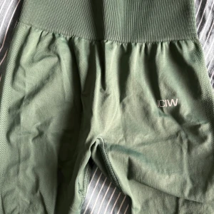 Gröna seamless tights från ICANIWILL XS - Snygga mossgröna seamless tights från ICANIWILL i modellen Define. Hög midja med ribbad linning och tight passform. Perfekta för träning och har diskret logga på benet. Materialet är stretchigt och andas bra.