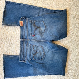 Levi's blå lågmidjade bootcut jeans  - Snygga blå Levi's jeans med utsvängda ben. De är lågmidjade och passar storlek 36! Skit snygg gammal modell! 🥰Liten skavank vid bältbanden, ett litet hål, syns inte när man bär byxorna!