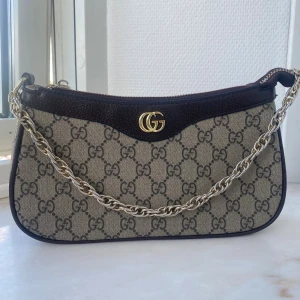 axelväska med kedja - Superfin väska i nyskick! Dragtappen har gått av och behöver fixas (lätt fix hemma), därav det låga priset. 🤎🤎🤎