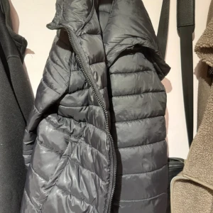 Svart pufferjacka från ONLY, M - Svart pufferjacka från ONLY med huva och dragkedja framtill. Jackan är quiltad och har en klassisk, lite längre modell som håller dig varm under kyliga dagar. Perfekt för dig som gillar en enkel och stilren look💗